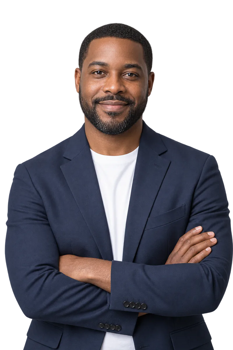 Man with a short beard in a navy blazer and white t-shirt, arms crossed, smiling at the camera
